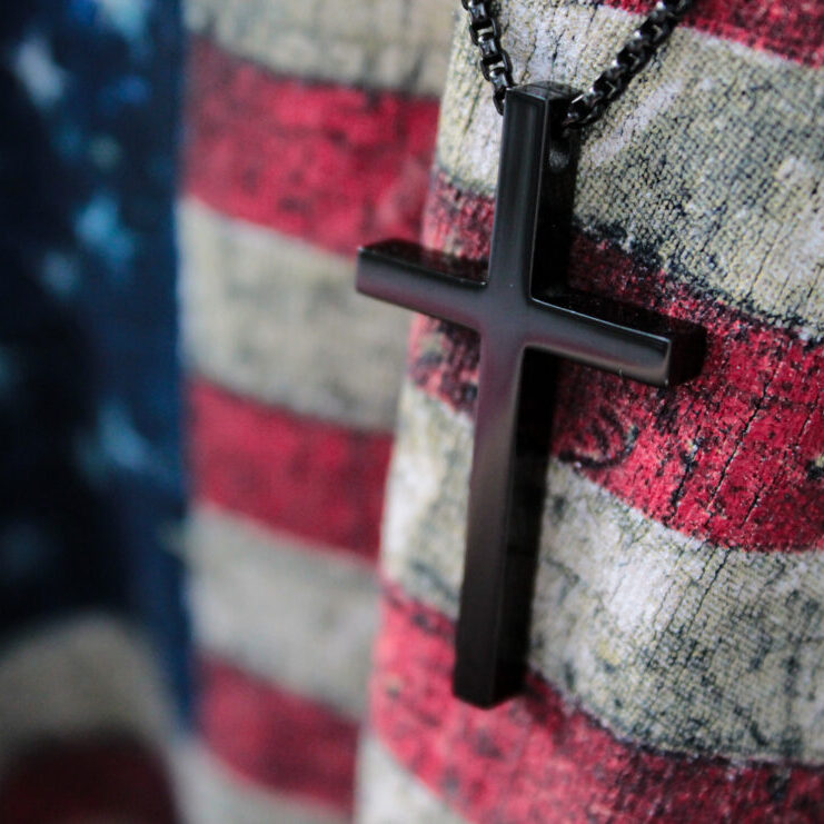 A small wooden cross and flag of USA. God save America