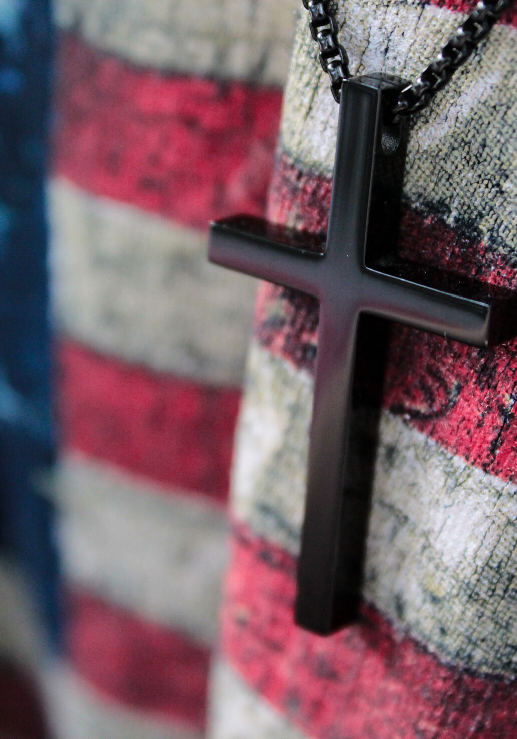 A small wooden cross and flag of USA. God save America
